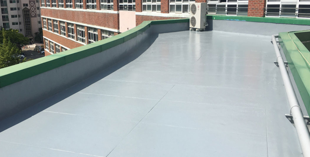 메리씰 250 시공 사진으로 학교 건물 옥상 바닥이 밝은 회색으로 코팅되어 있다.